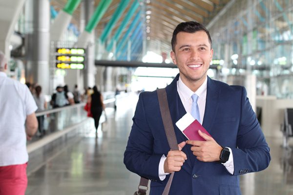 Handsome businessman smiling at the airport with space for copy